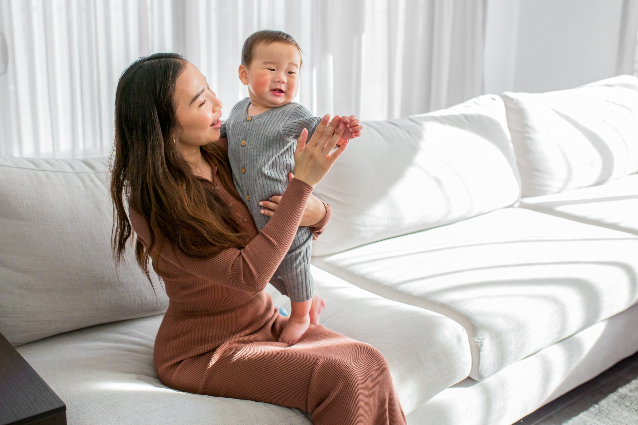 Women playing with a colic baby that is crying in the living room